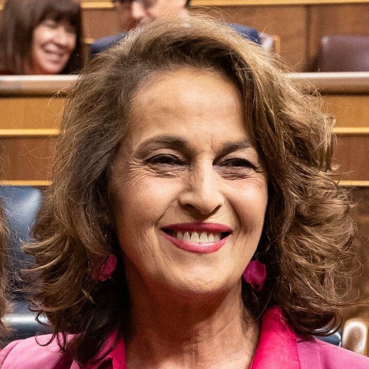 “Primo piano di Carla Antonelli sorridente in aula istituzionale, con capelli sciolti e giacca fucsia.