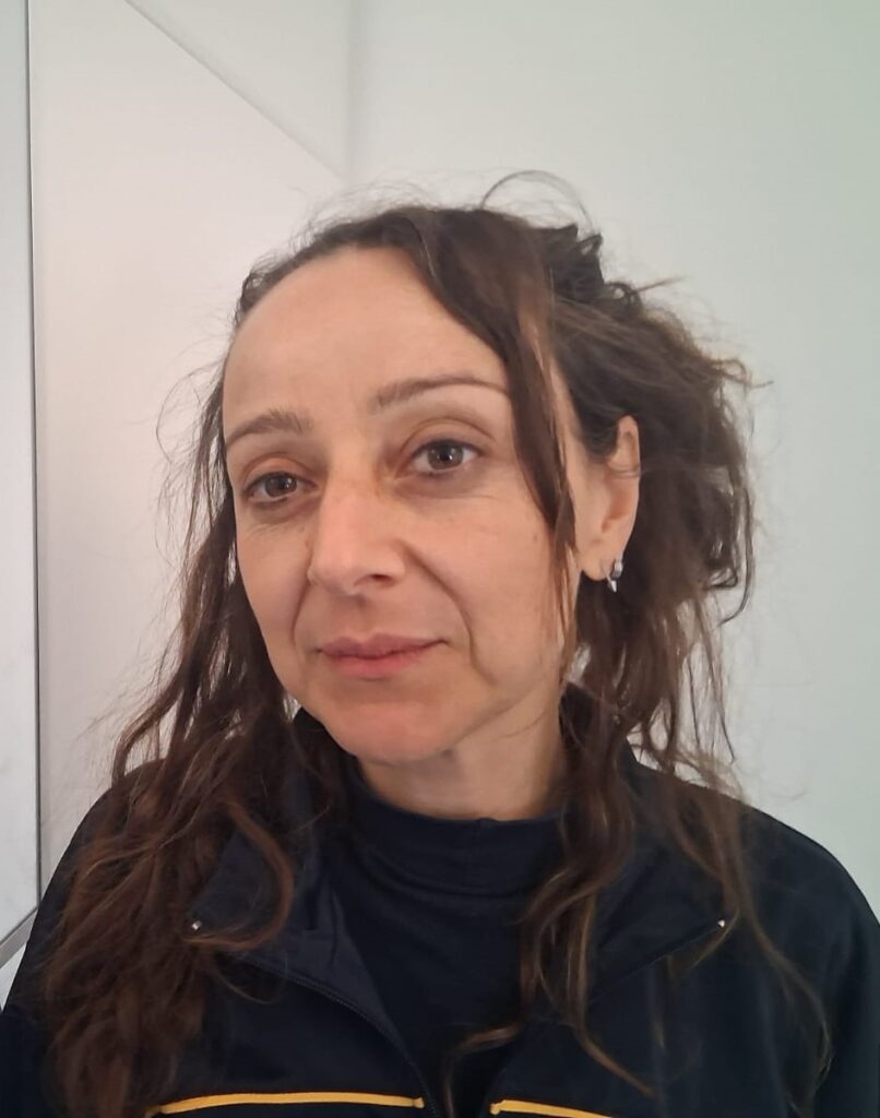 Ritratto a mezzo busto di Fulvia Antonelli in abbigliamento scuro, con capelli raccolti e sguardo verso camera su sfondo chiaro.